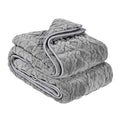 Grey sherpa fleece weighted blanket folded on a bed